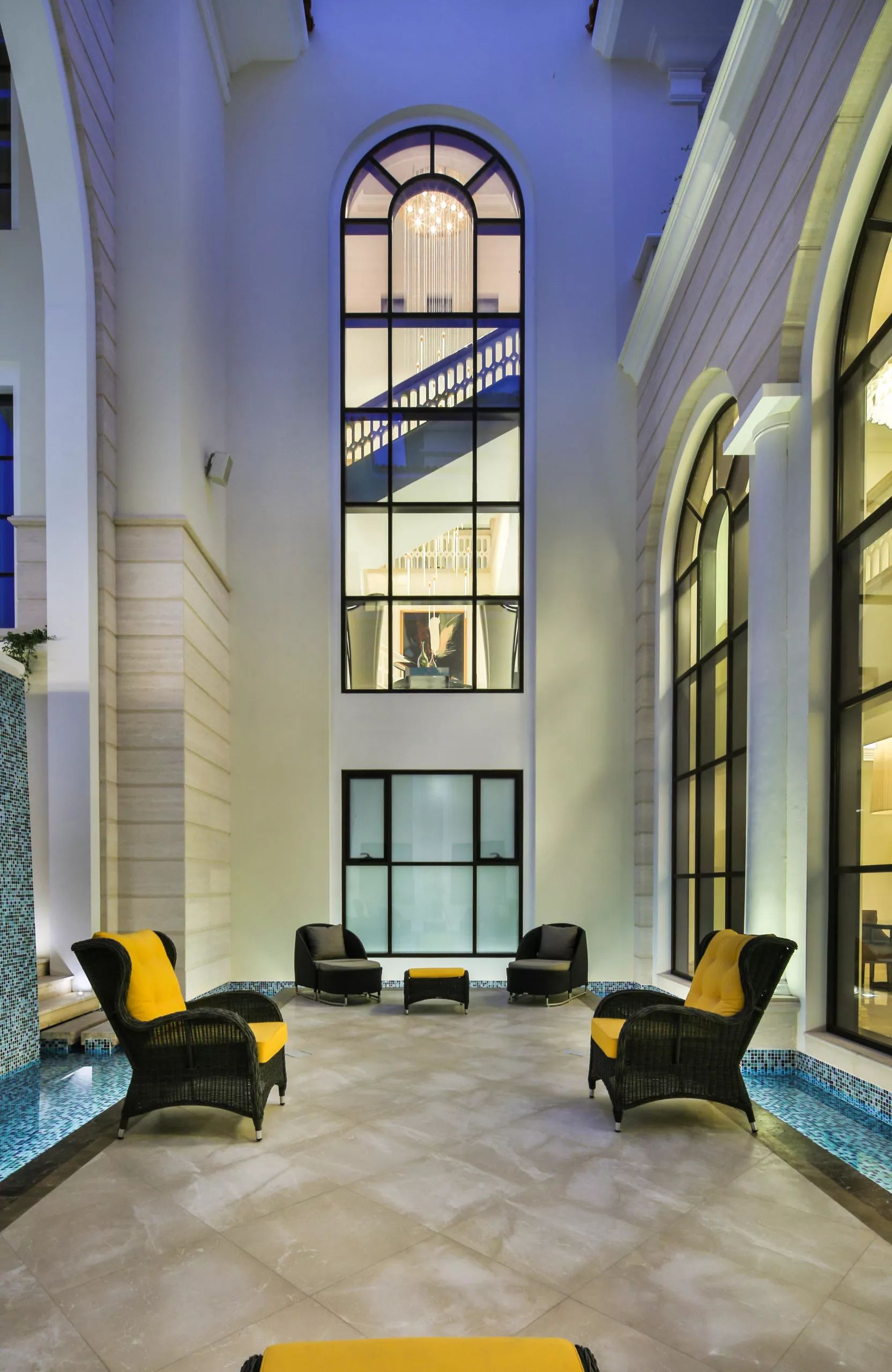 Double-height courtyard with arched windows and a pool