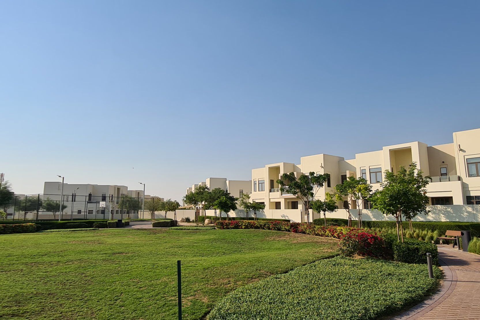 Townhouses and a landscaped park under a clear sky